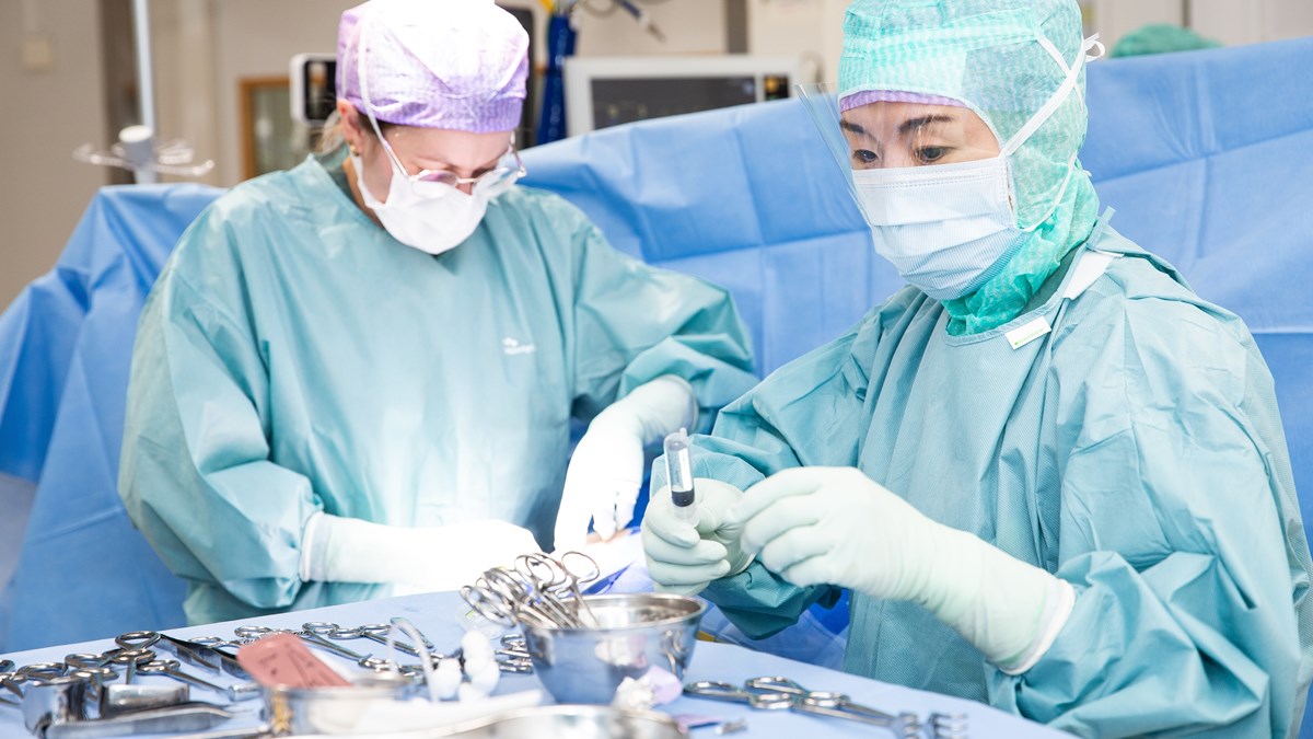 Två personer som arbetar i en operationssal.