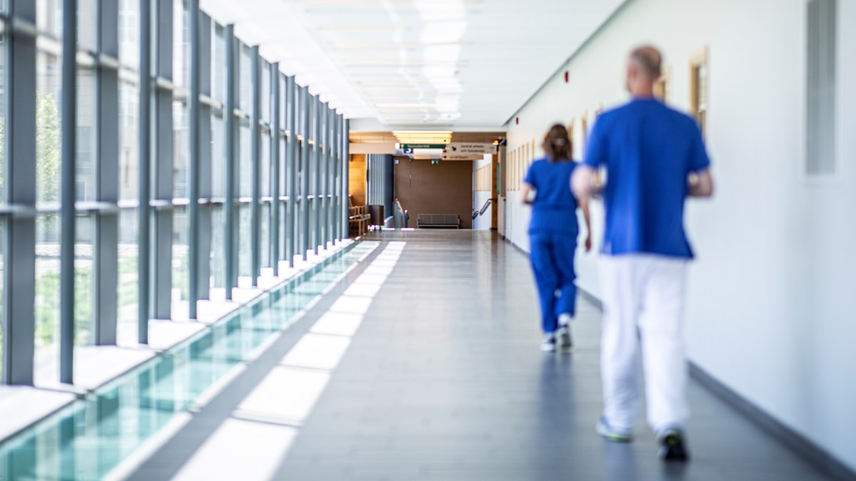 Sjukhuspersonal går i korridor.